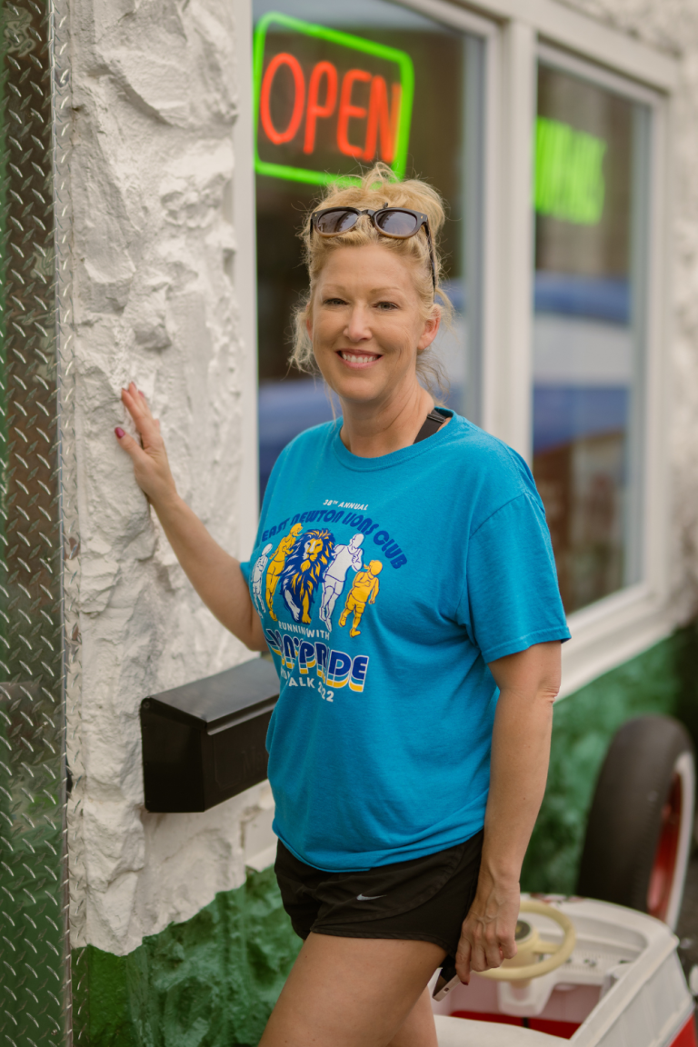 Mandy smiling in blue graphic t-shirt standing outdoors during a girls trip