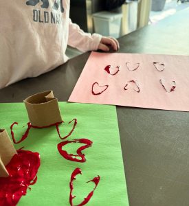 Easy Valentine’s Day craft for toddlers using cardboard tube heart stamps and red paint at home