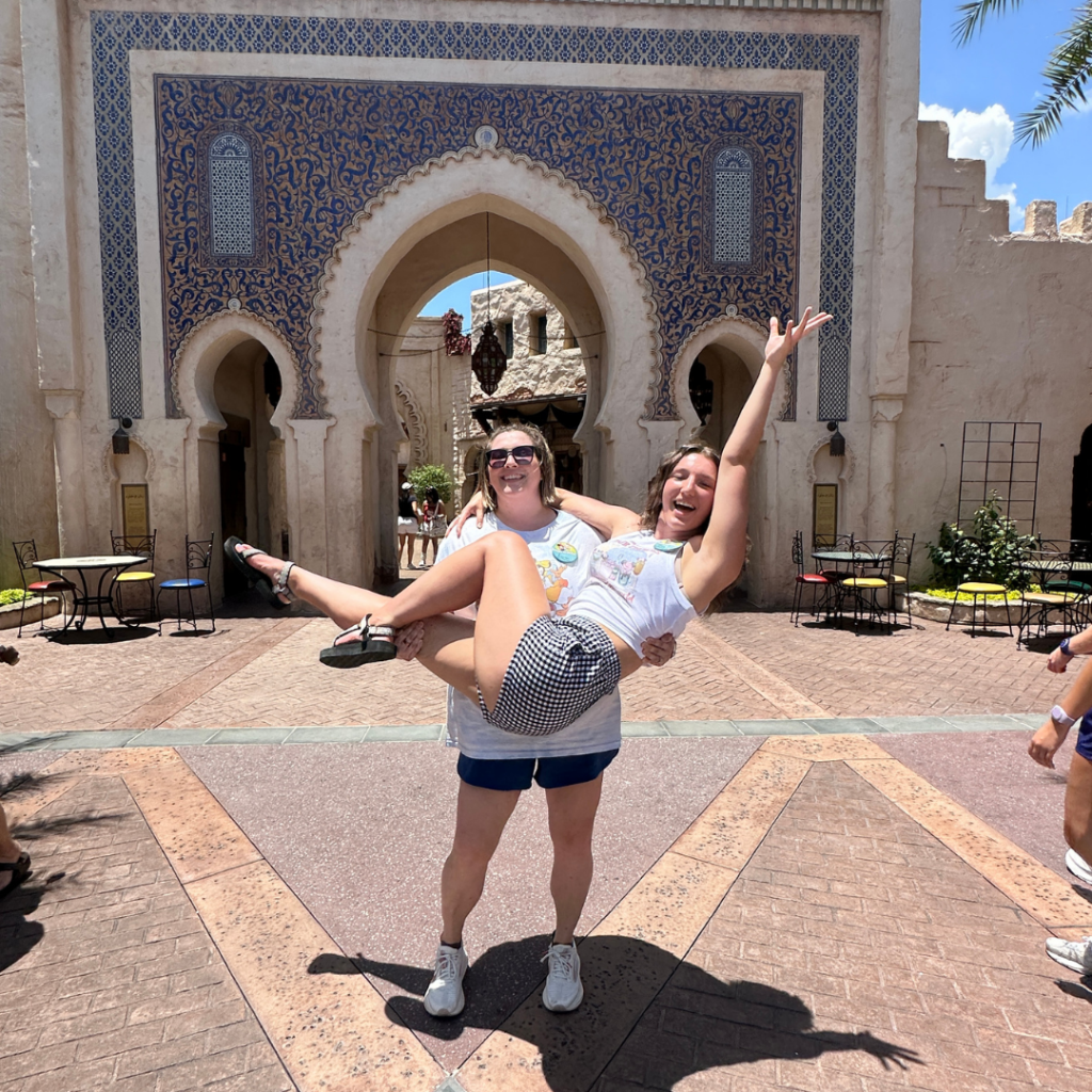 Lauren Holding her sister Gracie being silly at Disney's Epcot for drinking around the world