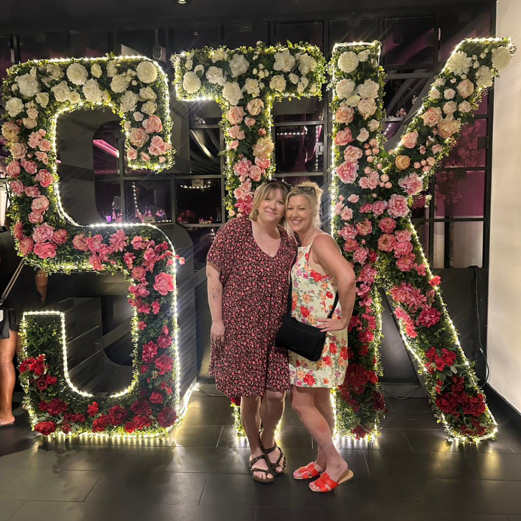 Mandy and Lauren in front of the STK sign at Disney Springs
