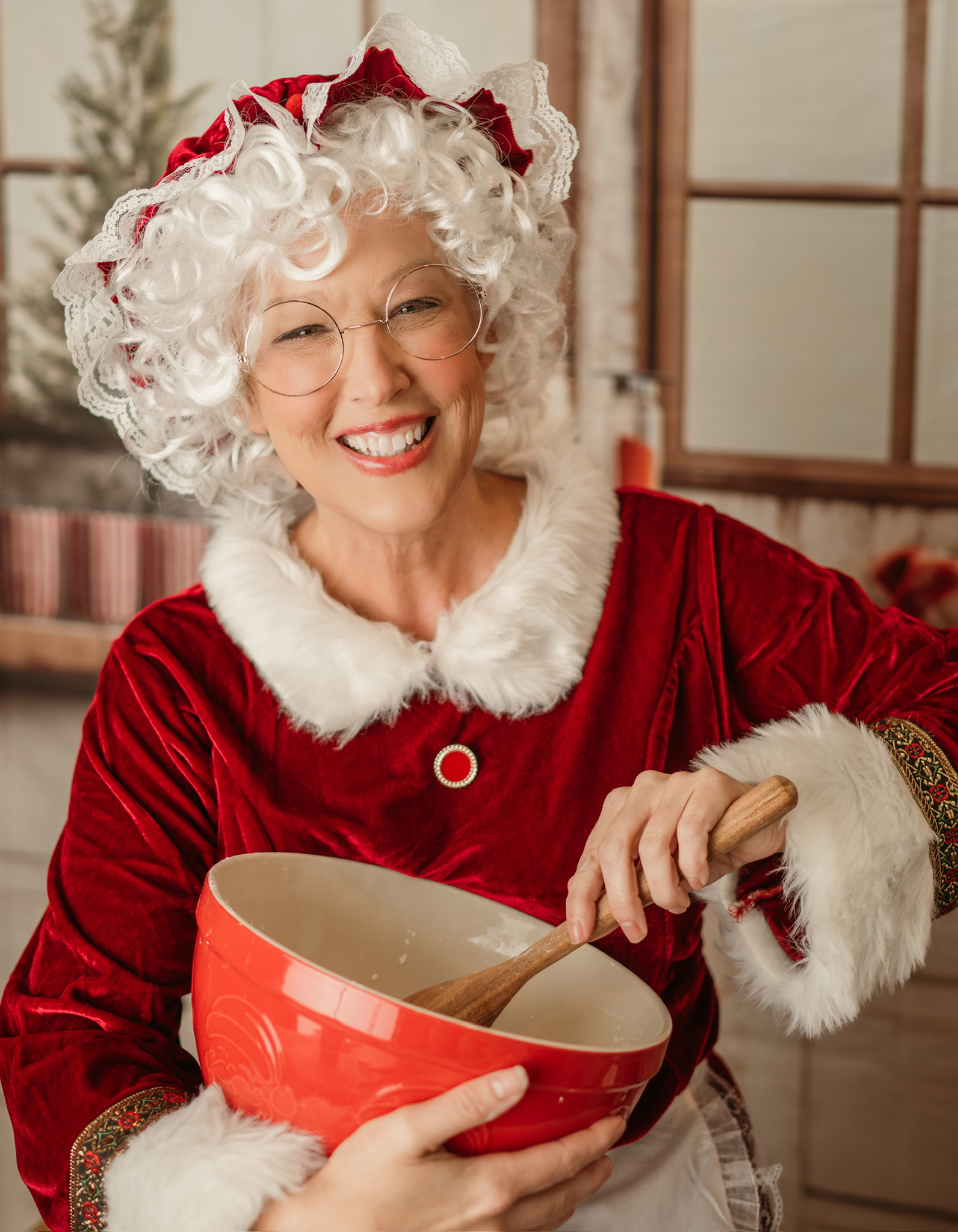 Mrs Claus Smiling and mixing cookie dough in a red bowl